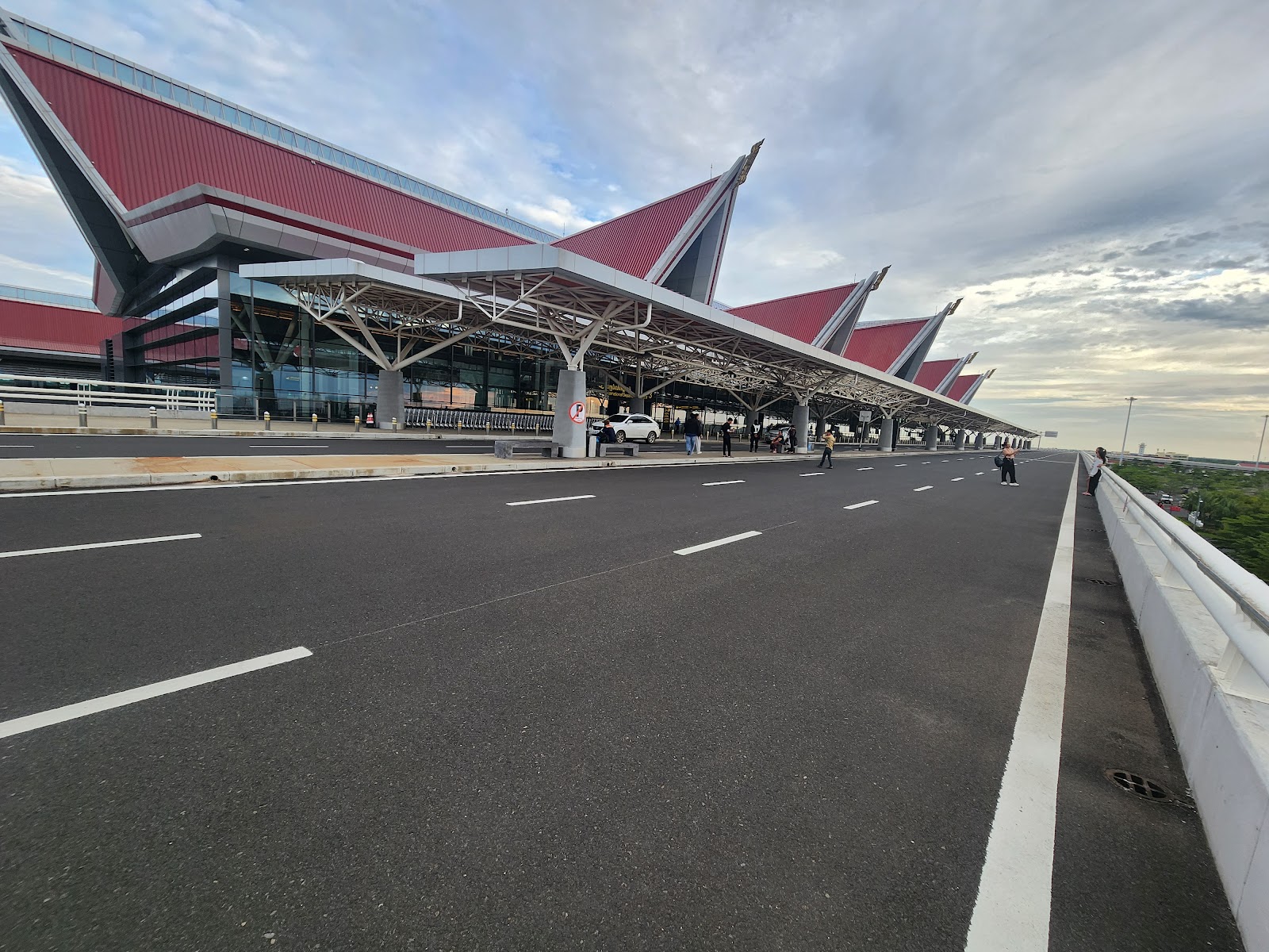 The departures curb and red peaked roofs of the terminal at Siem Reap Angkor International Airport