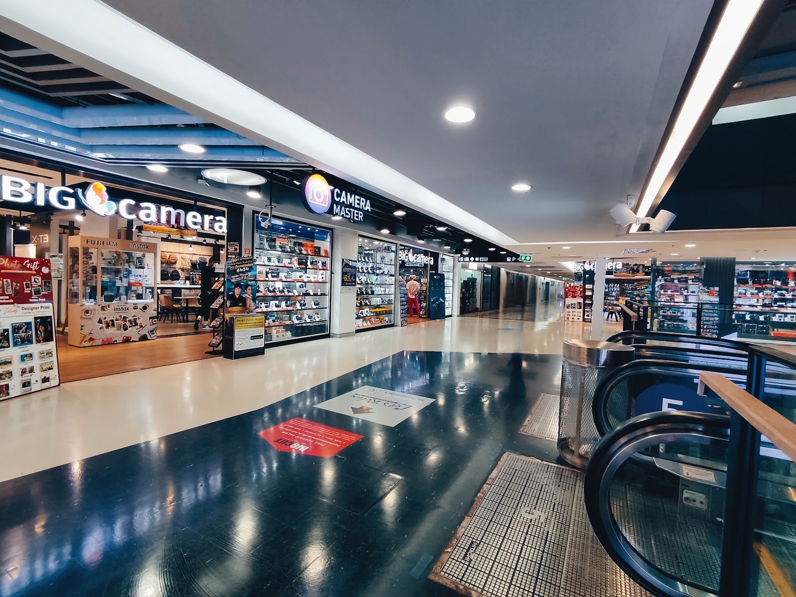 A corridor at MBK Center lined with electronics and camera shops, including Big Camera