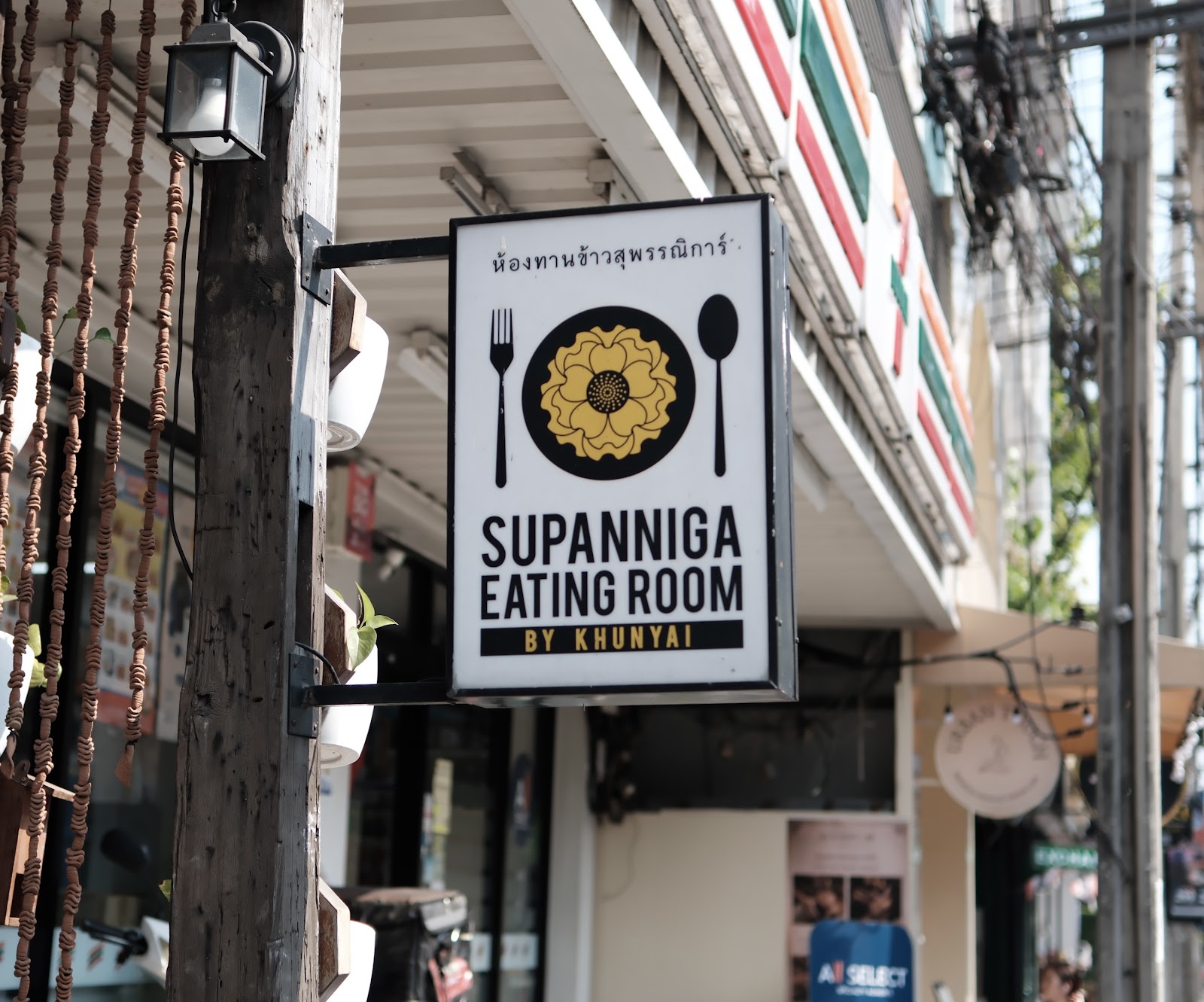 The hanging sign of Supanniga Eating Room outside its shophouse on Thonglor