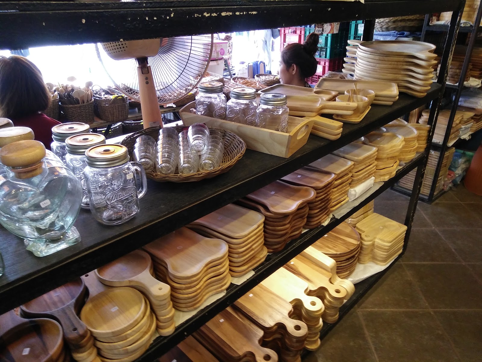 A market stall stacked with wooden trays, bowls and glass jars at Chatuchak Weekend Market