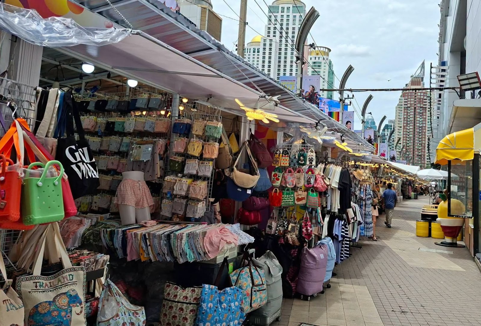 Bag and accessory stalls along the covered walkway outside Platinum Fashion Mall