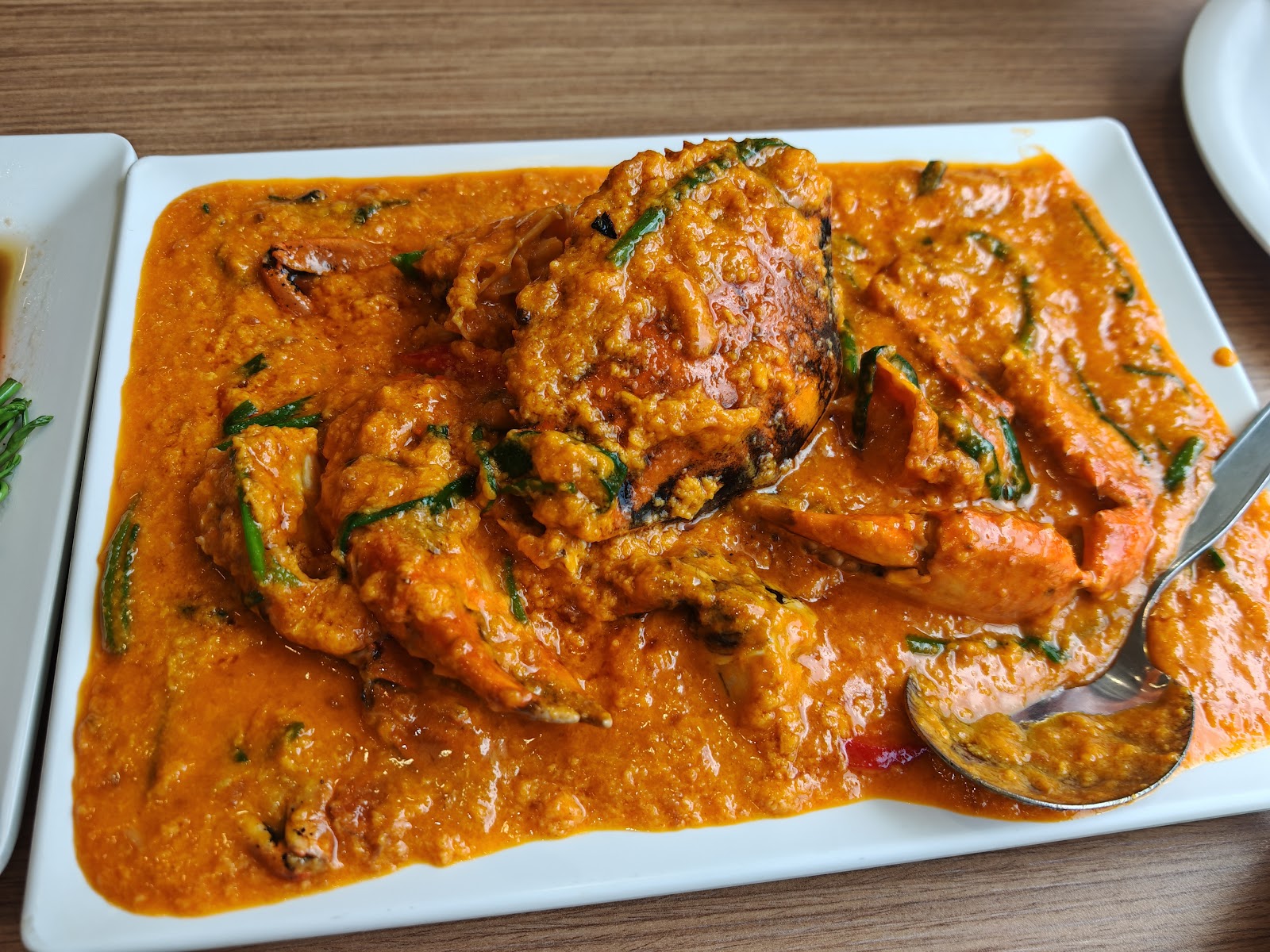 A platter of fried curry crab in a thick orange curry sauce at Somboon Seafood