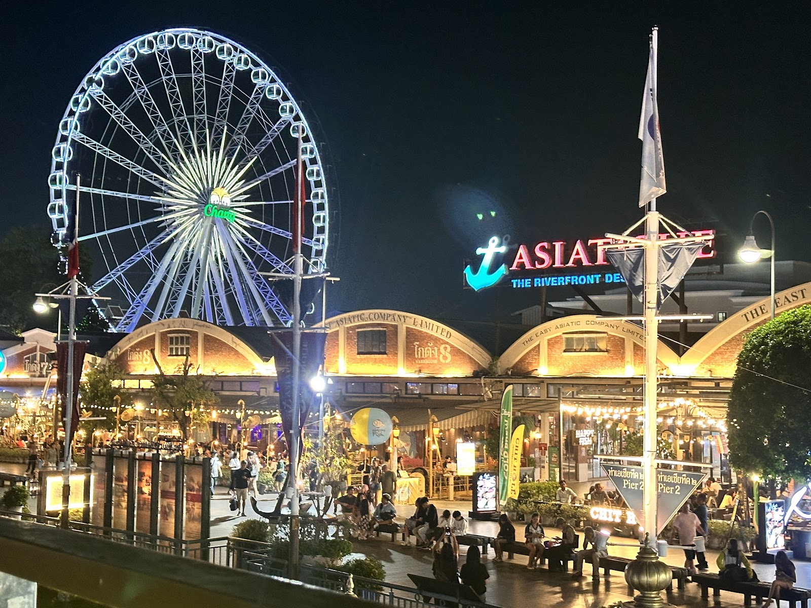 Asiatique The Riverfront at night with the Asiatique Sky Ferris wheel lit up behind the warehouse buildings