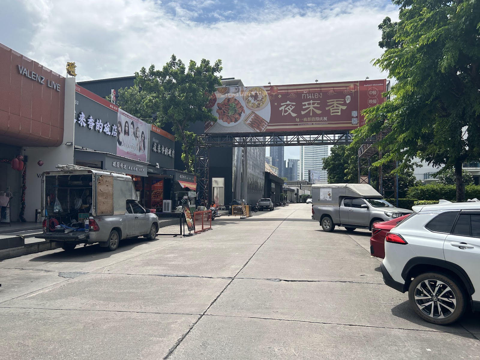 Royal City Avenue by day, a quiet street of low buildings with parked cars