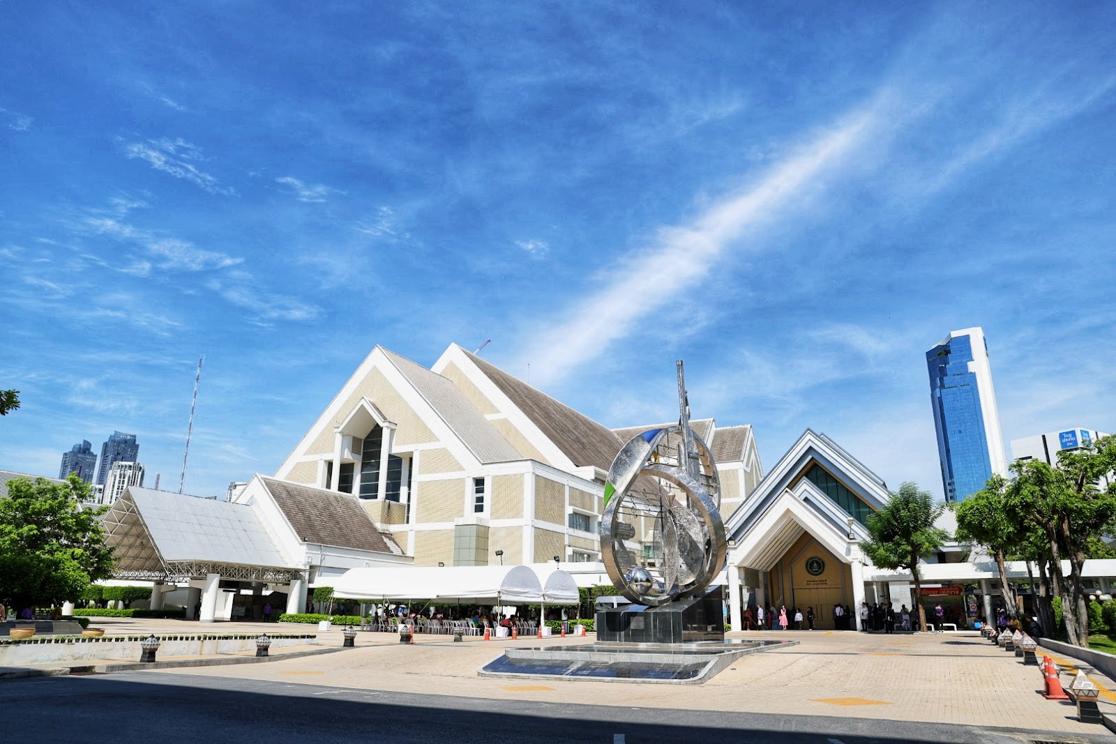 The white, peaked roofline of the Thailand Cultural Centre with a steel sculpture in the forecourt