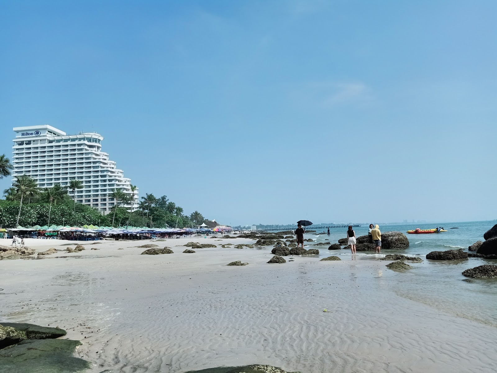 Sand, rocks and a tall beachfront hotel on Hua Hin Beach