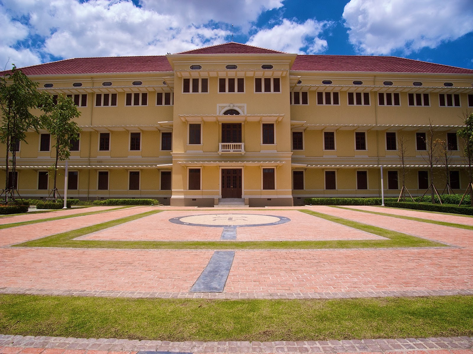 The yellow facade of Museum Siam, the former Ministry of Commerce building, across its front lawn