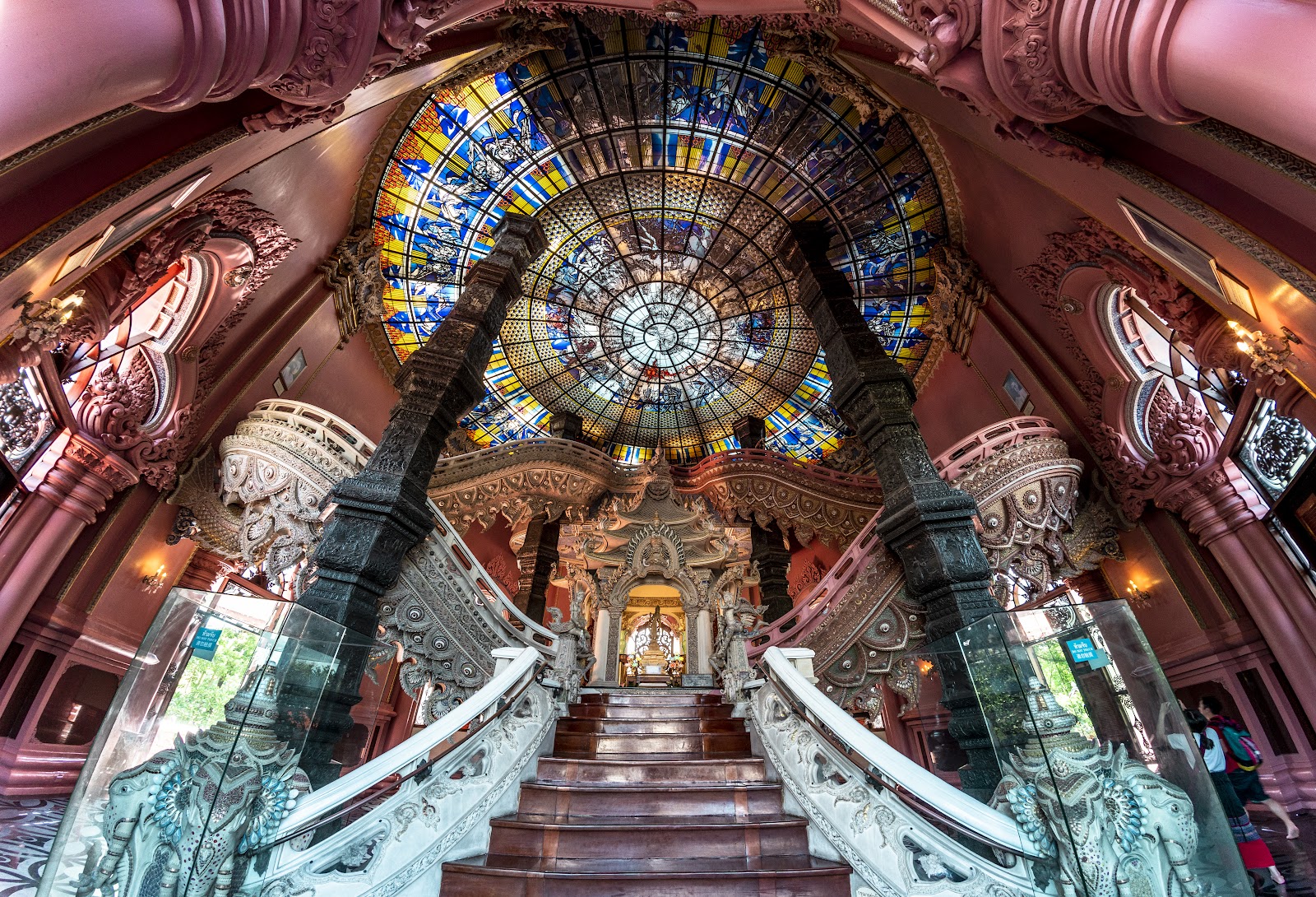 The ornate staircase and stained-glass ceiling inside the Erawan Museum