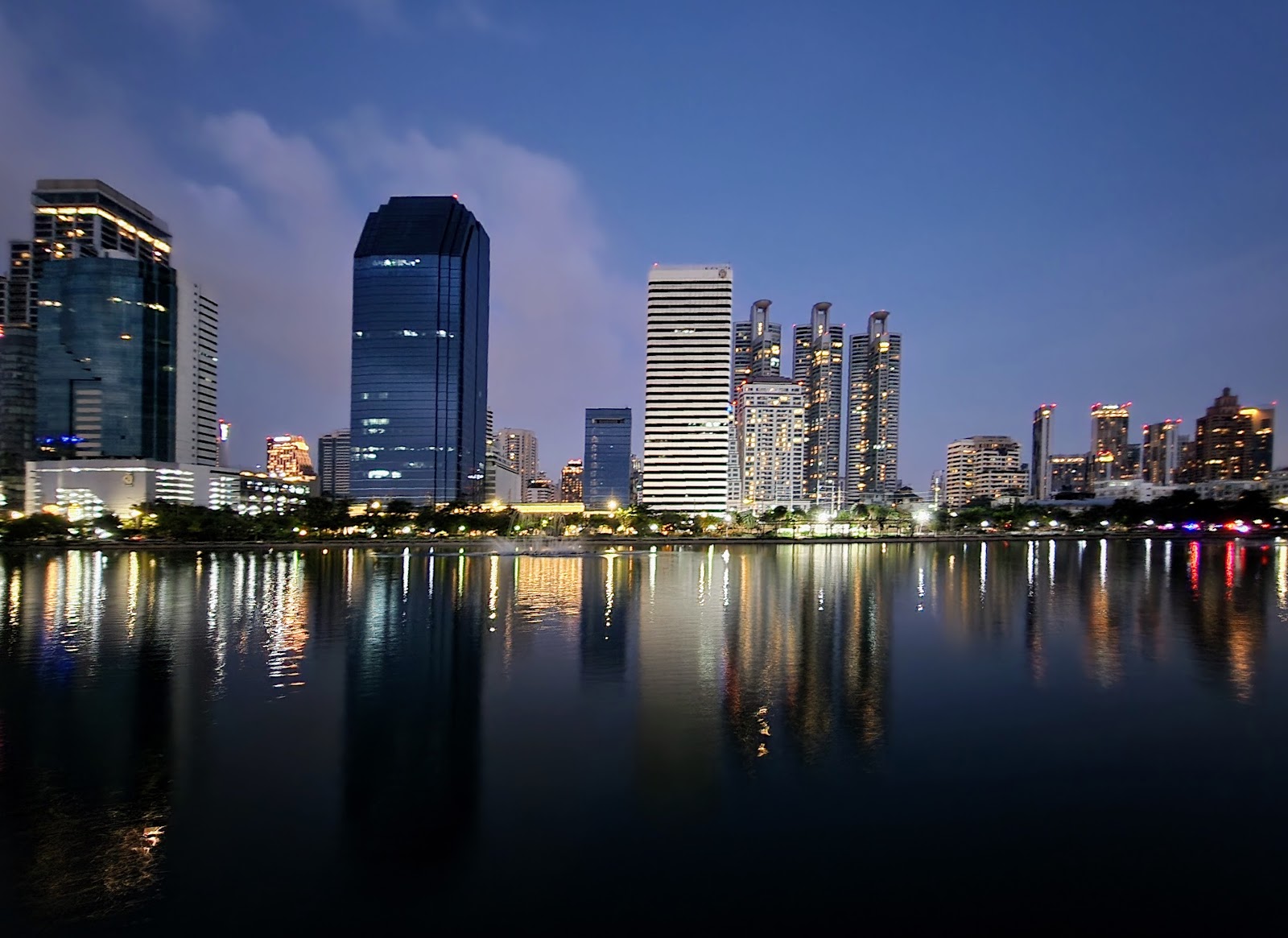 The lake at Benjakitti Park at dusk with office and residential towers reflected in the water
