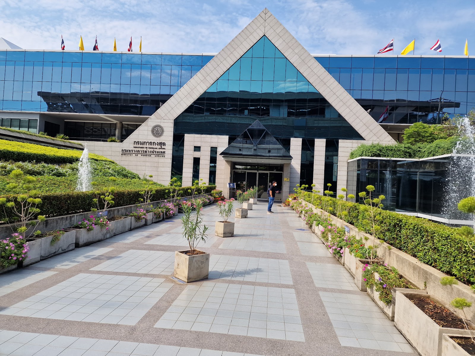 The entrance walkway and glass facade of the Department of Consular Affairs building on Chaeng Watthana Road
