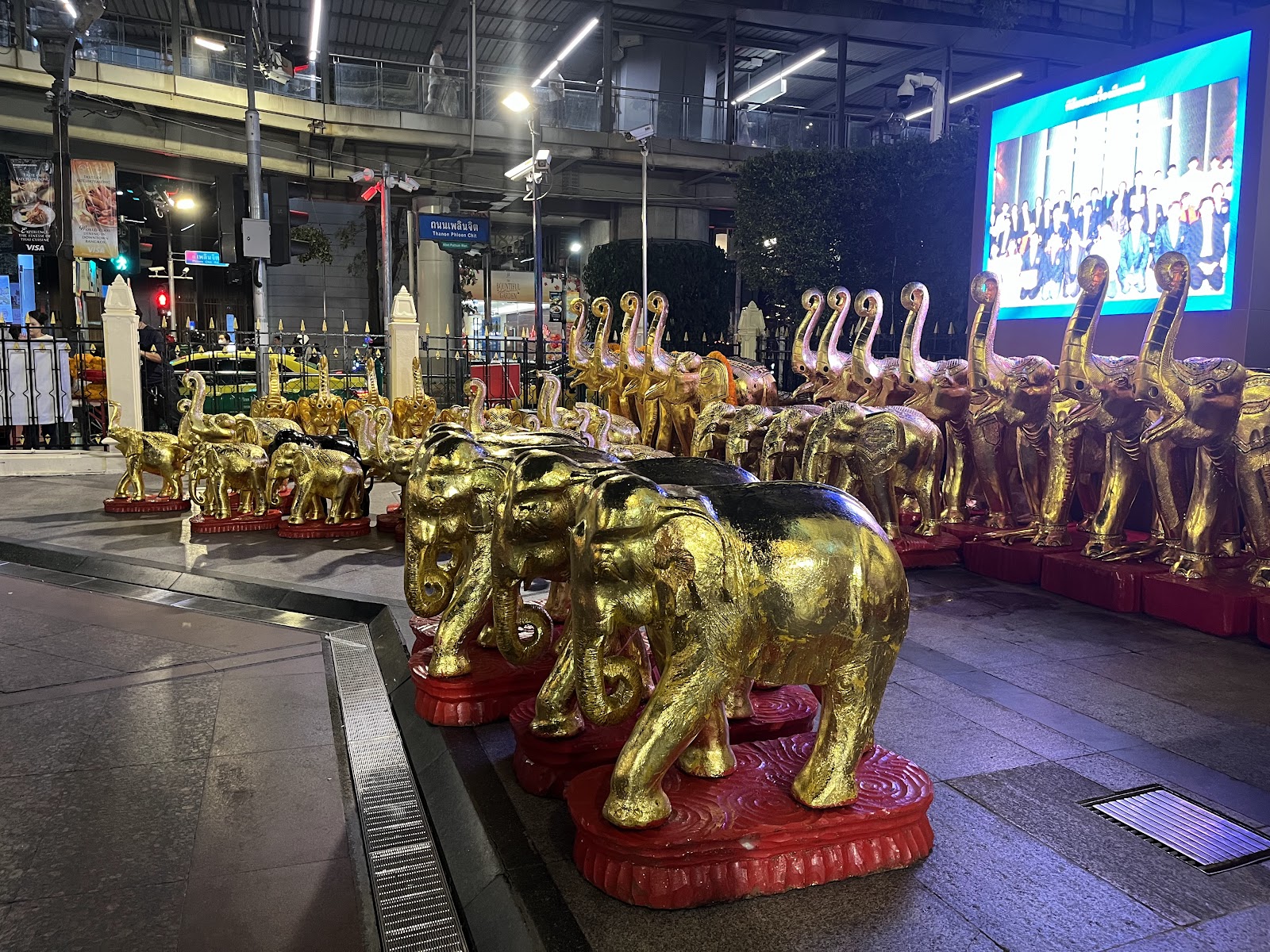Rows of carved and gilded elephant figures left as offerings at the Erawan Shrine in the evening