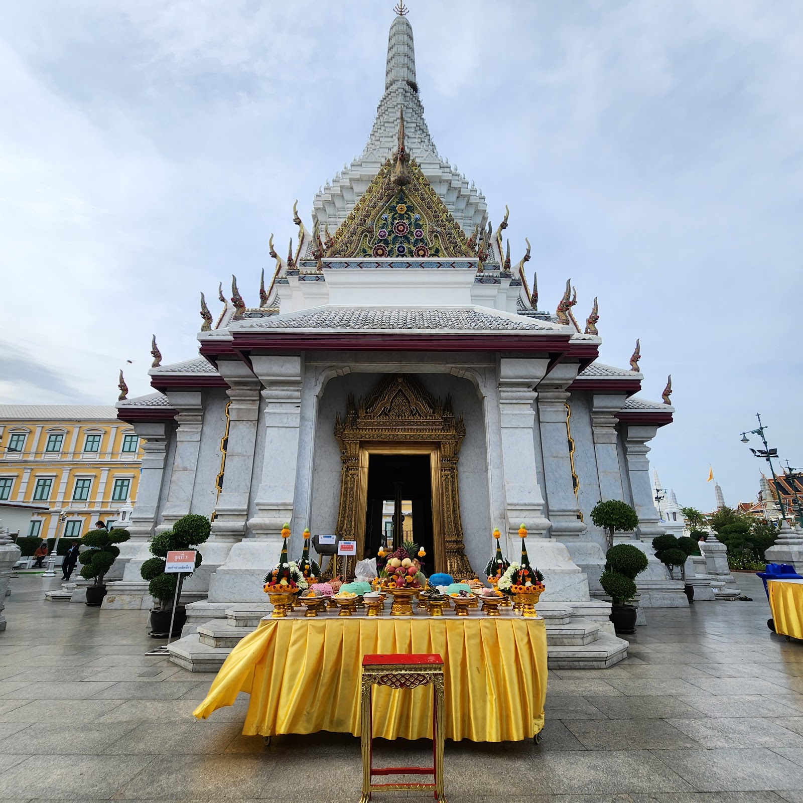 The white City Pillar Shrine with its tall spire and offerings in front