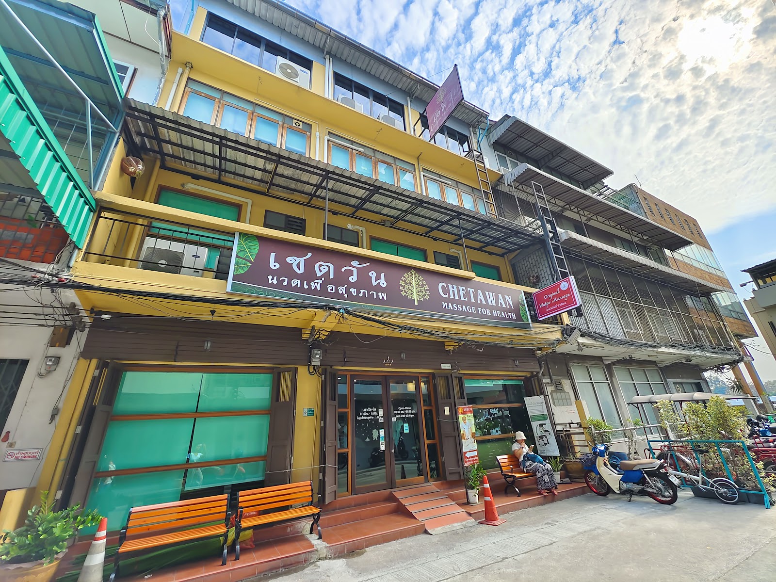 The shophouse front of the Chetawan massage school building with its green and gold sign