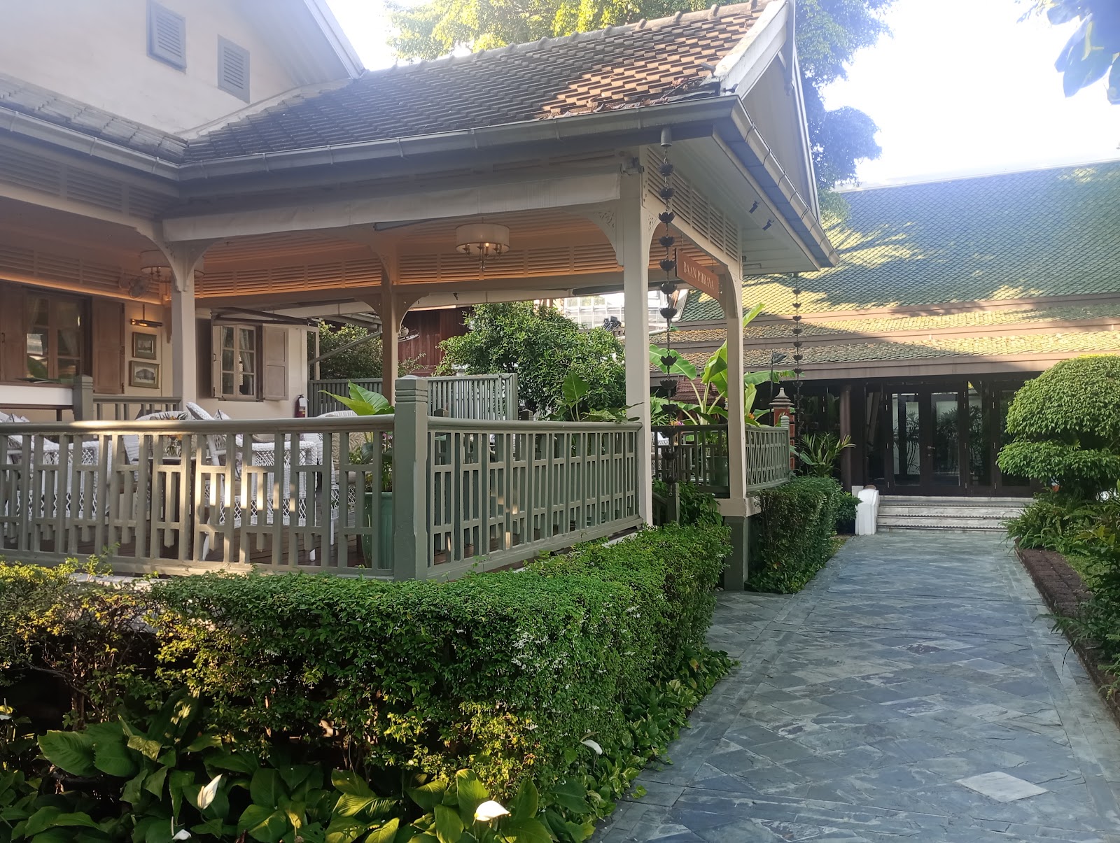 The teak buildings and garden path of The Oriental Spa across the river from Mandarin Oriental