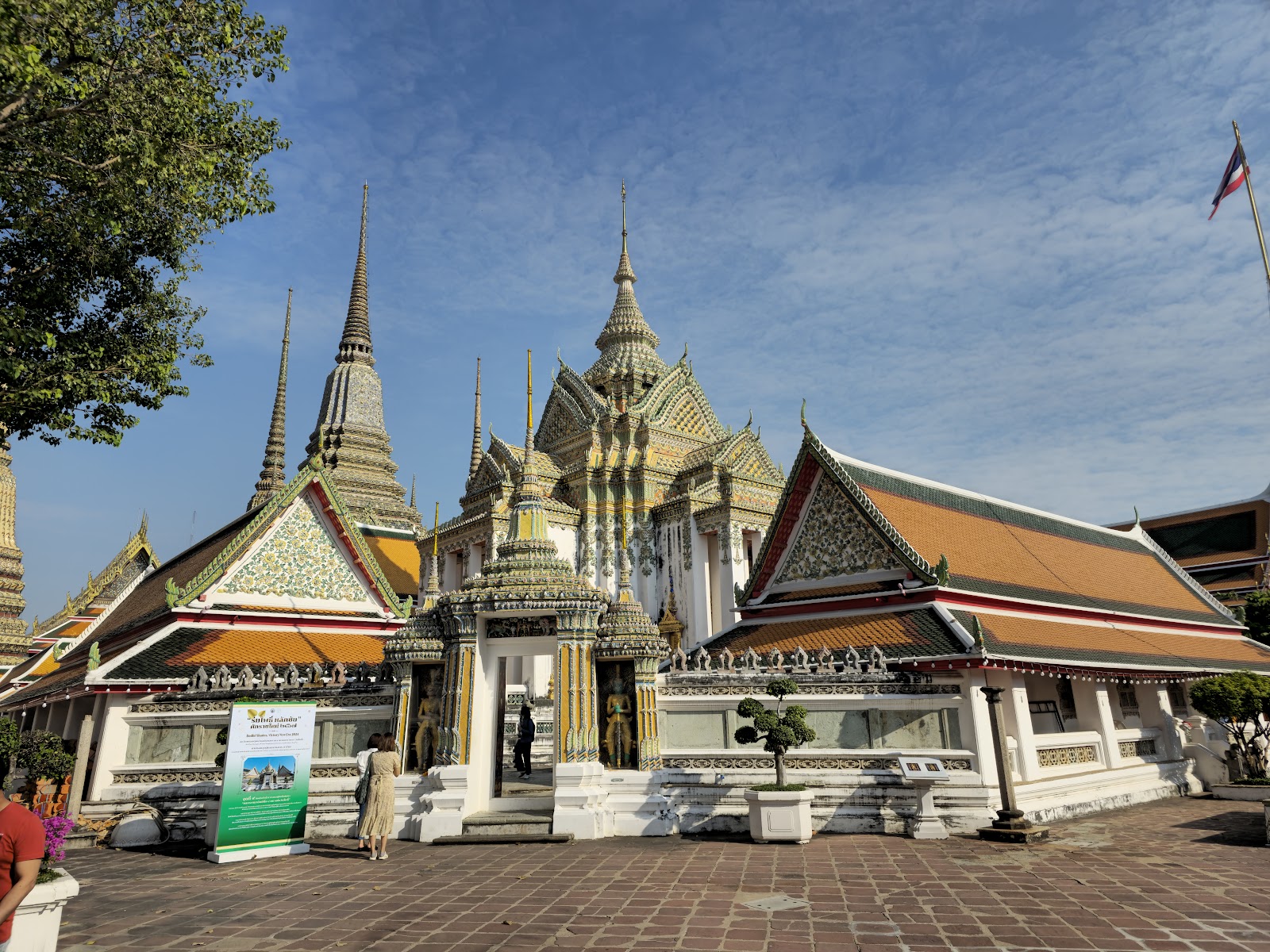 Ornate halls and spires at Wat Pho under a blue sky