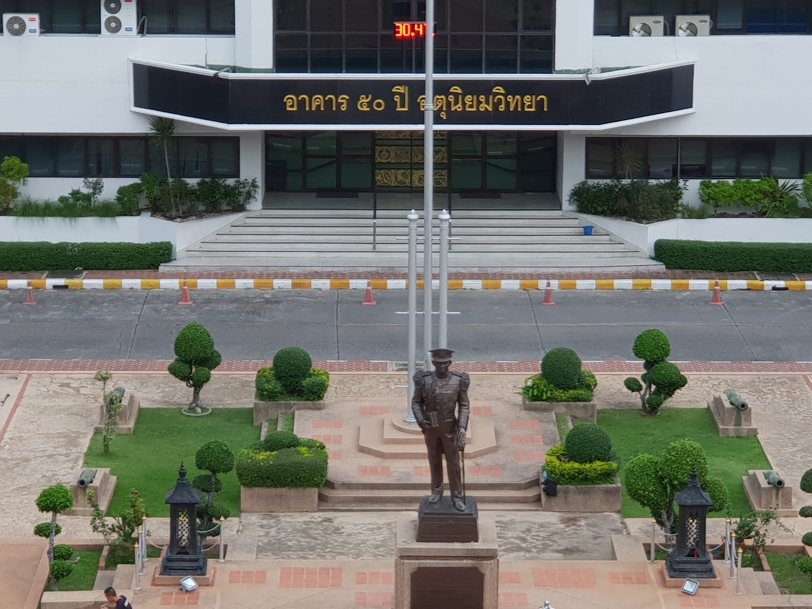 The entrance of the Thai Meteorological Department building with a statue in the garden in front