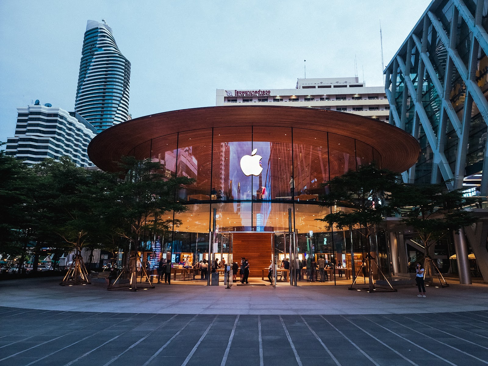 The round glass pavilion of Apple Central World with its wooden canopy, in front of the centralwOrld towers