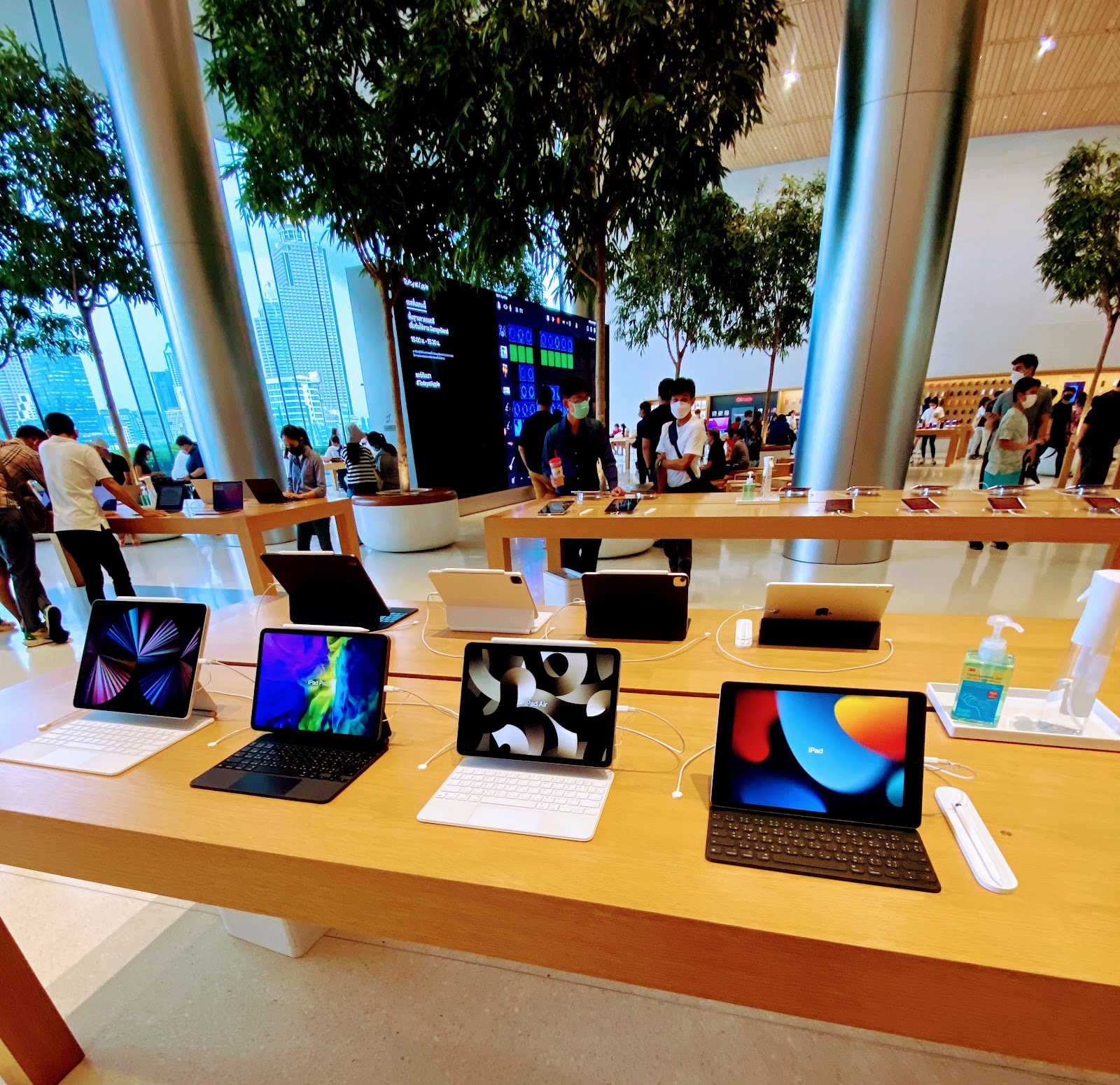 iPads with keyboards on display on a wooden table inside Apple Iconsiam