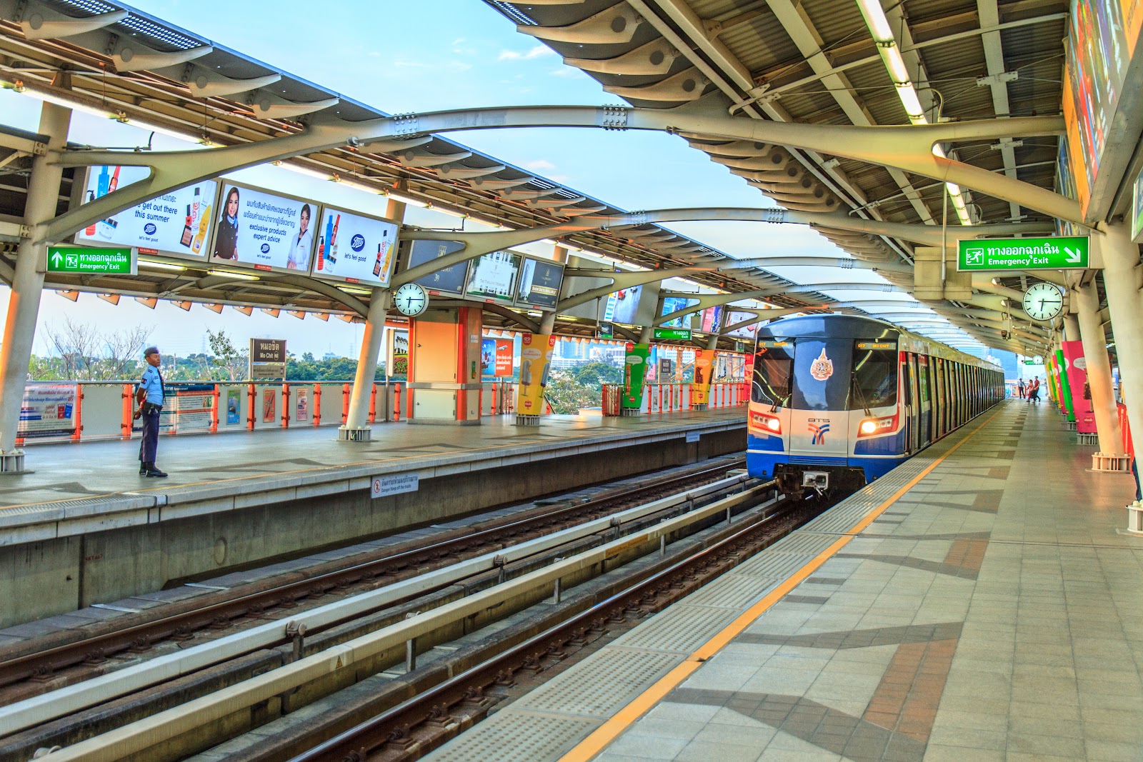 A BTS Skytrain arriving at the elevated platform of Mo Chit station