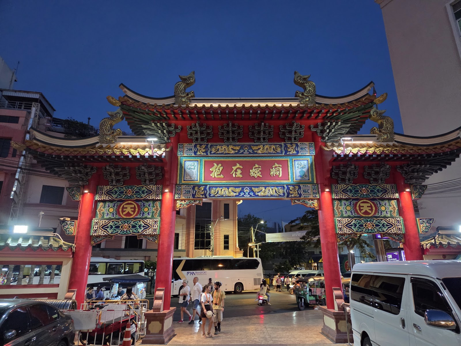 The red and gold Chinese gateway at the entrance to Bangkok's Chinatown at dusk