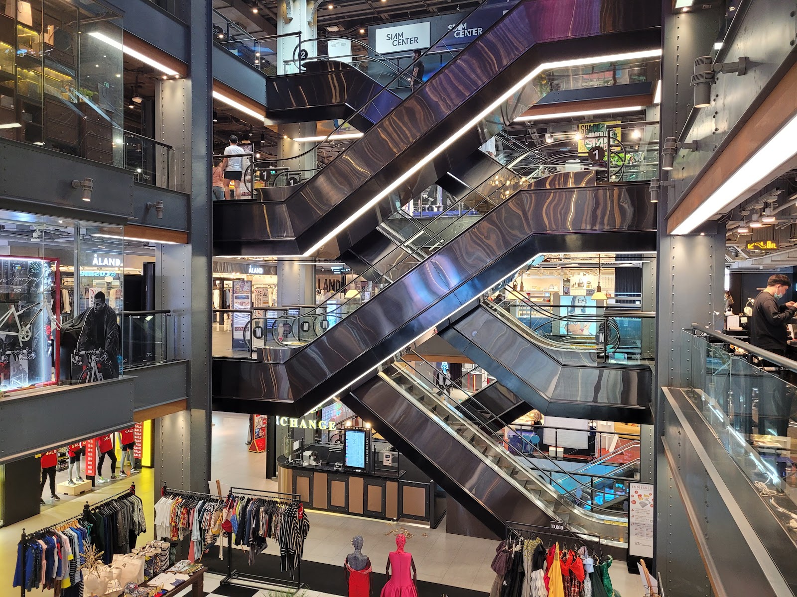 Escalators crossing an atrium above fashion shops inside Siam Center