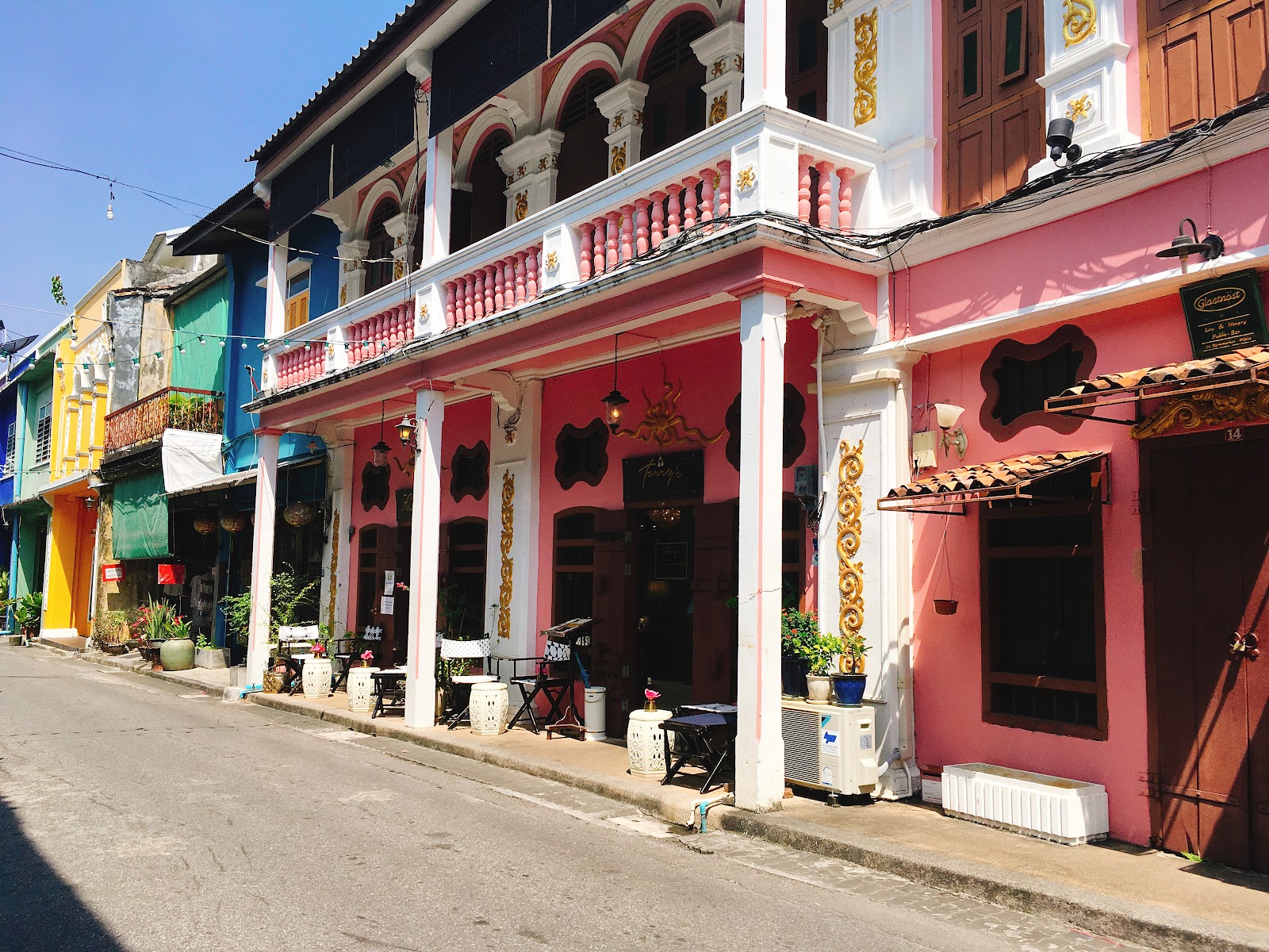 Colorful two-story Sino-Portuguese shophouses with arched colonnades along Thalang Road