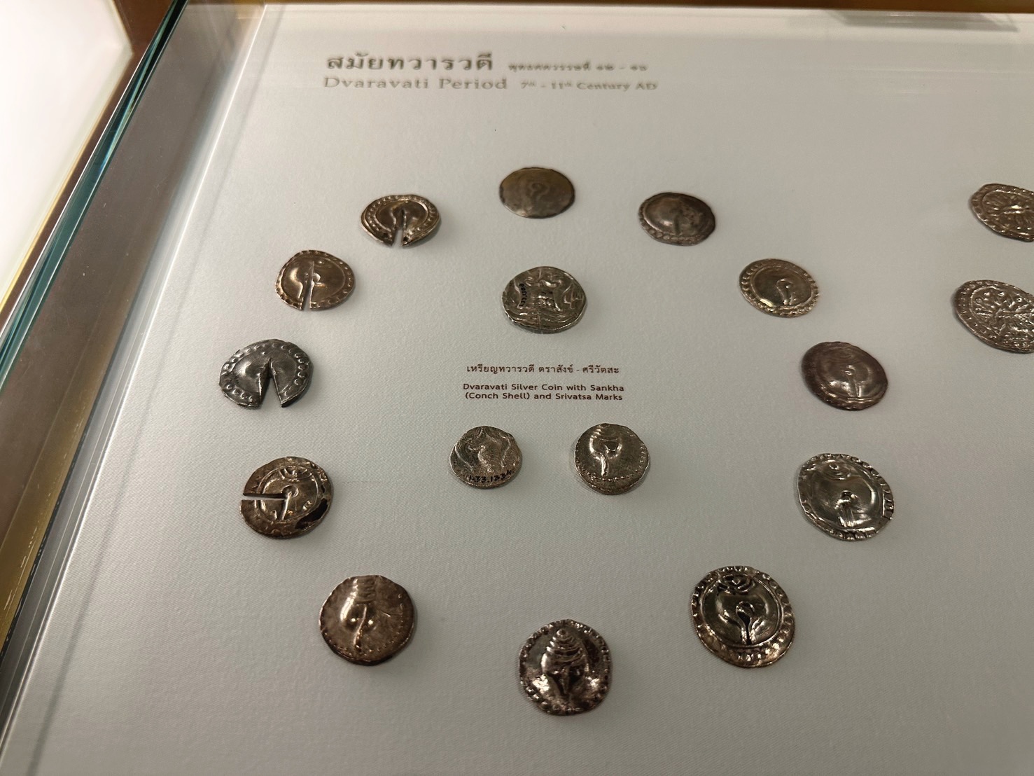 Early Thai coins displayed in a glass case at the Bank of Thailand Museum