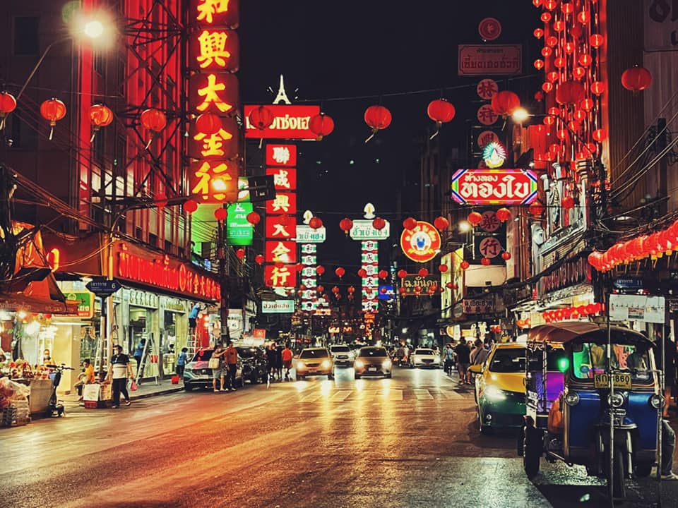 Yaowarat Road at night lined with red and yellow neon signs and street food stalls