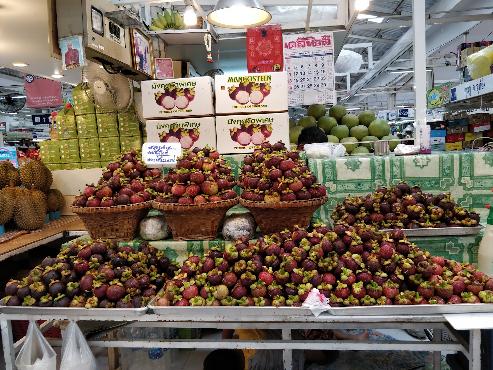 Baskets piled with mangosteens and other fruit at a stall in Or Tor Kor Market