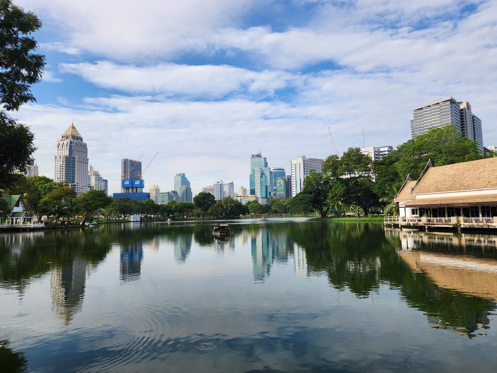 Clouds over the lake in Lumphini Park with the Silom skyline reflected in the water
