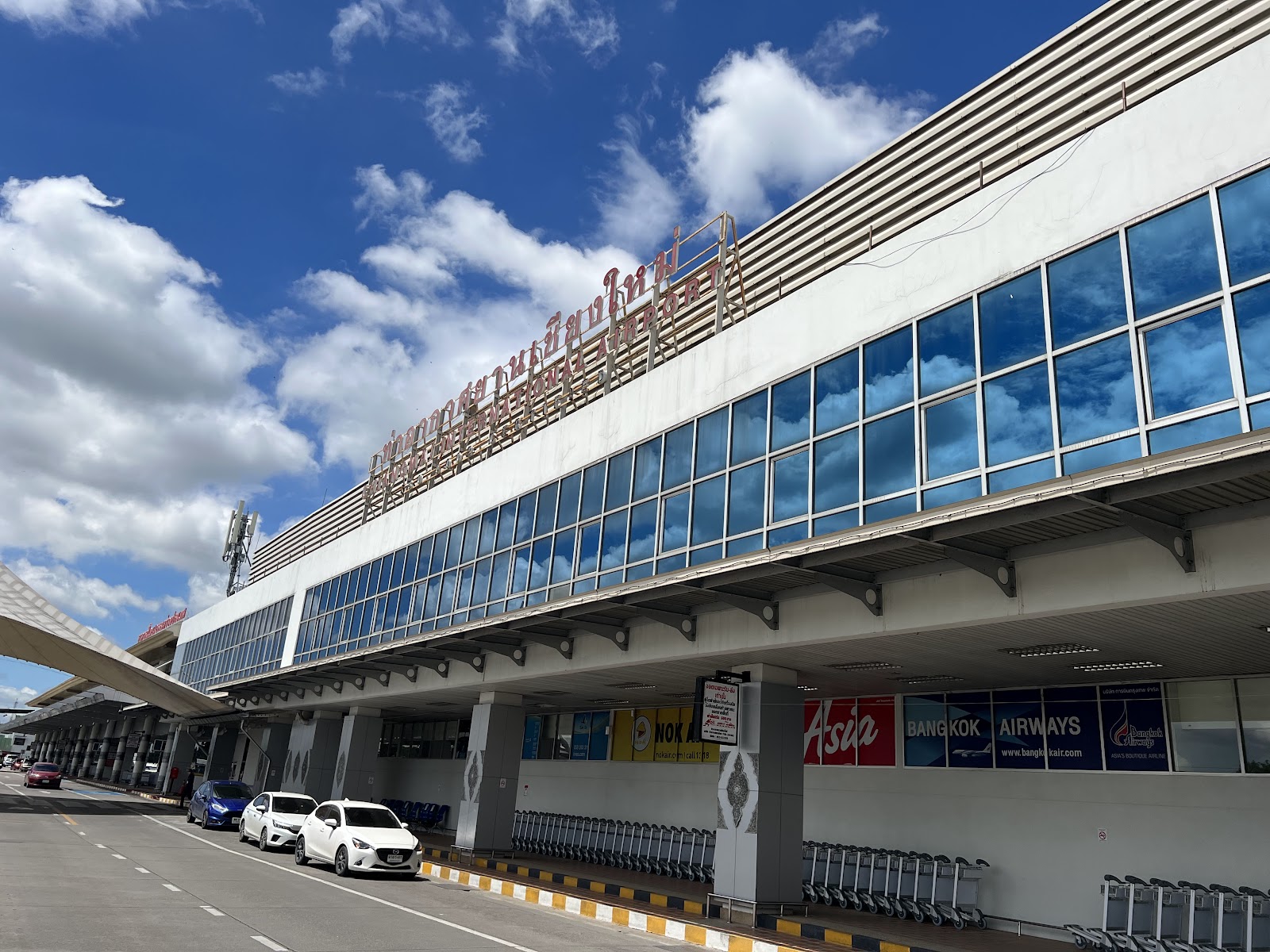 Terminal building of Chiang Mai International Airport under a blue sky with clouds
