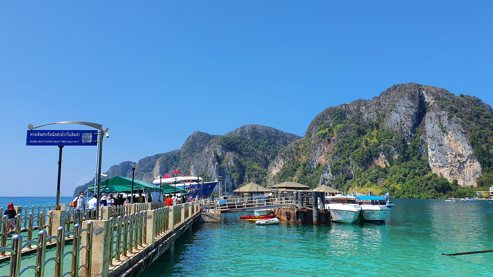 The long jetty at Ton Sai Pier on Ko Phi Phi Don with boats moored and hills behind
