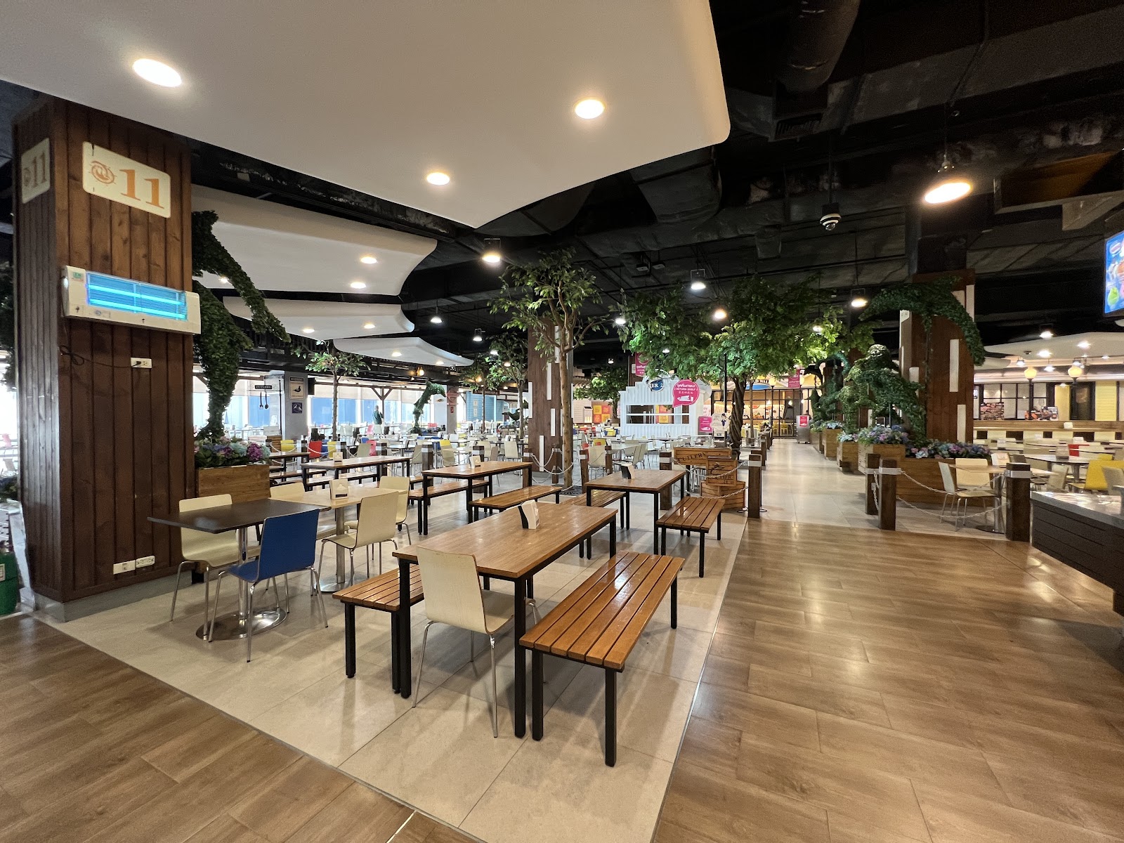 Wooden tables and benches in the seating area of the Pier 21 food court