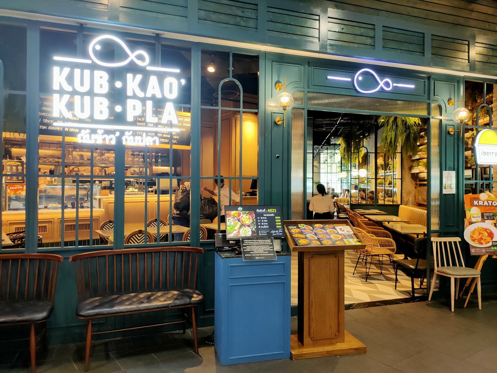 The blue shopfront of the Kub Kao Kub Pla restaurant with outdoor-style seating