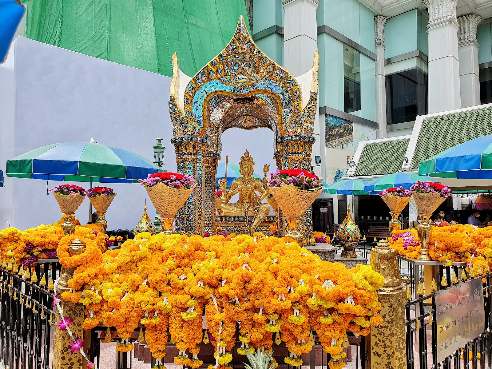 The gilded Brahma image at the Erawan Shrine surrounded by marigold garland offerings