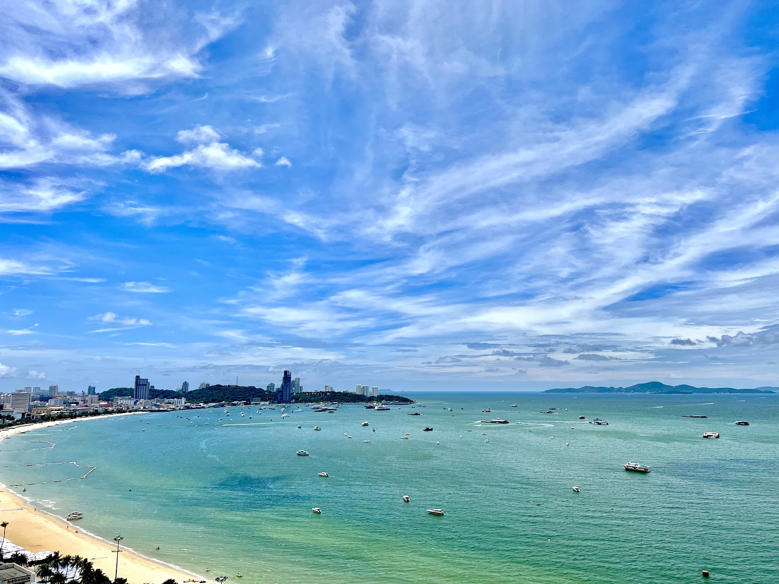 Pattaya Bay seen from above, with the curve of the beach and boats moored offshore
