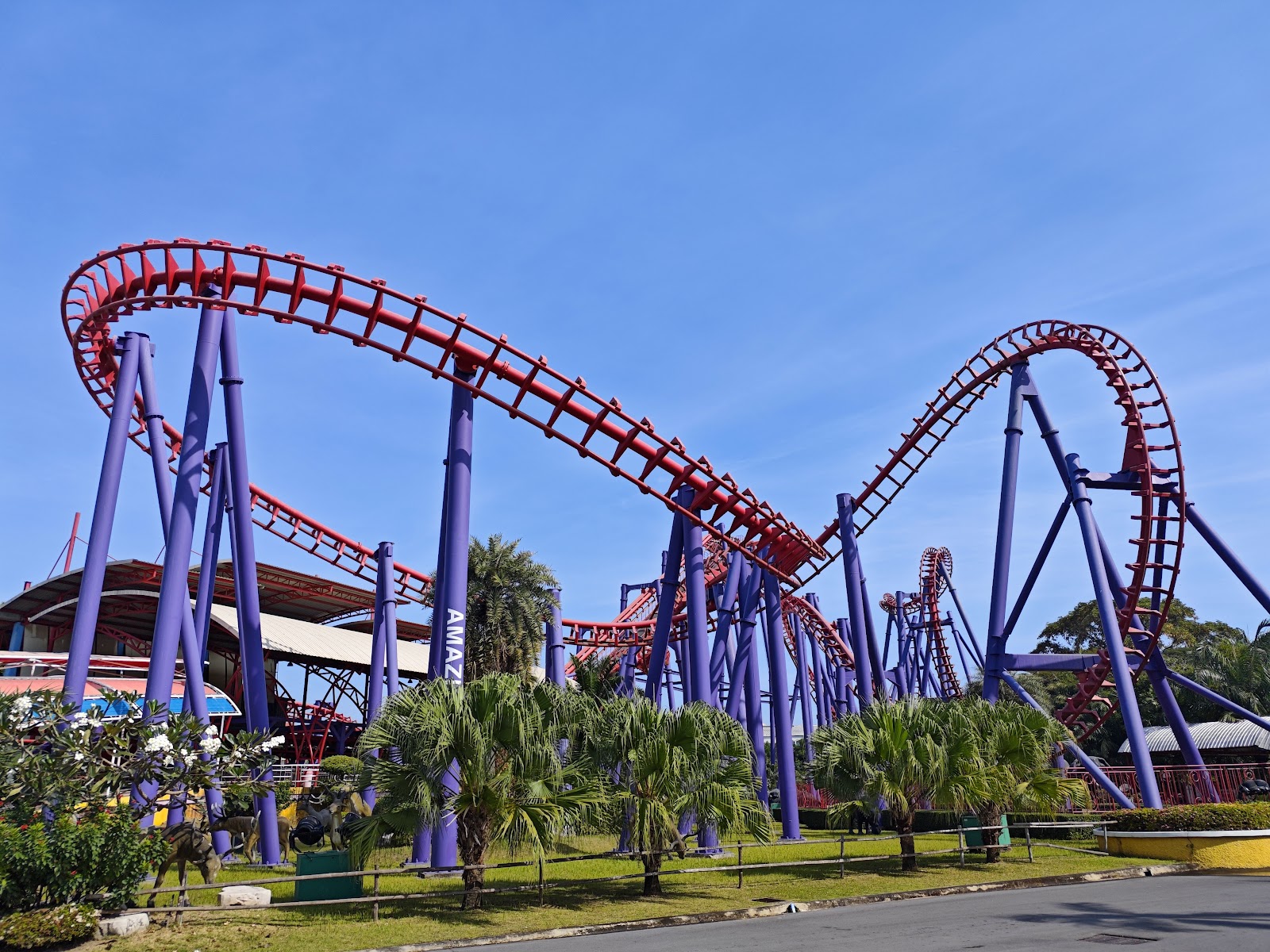 The red and purple looping roller coaster track at Siam Amazing Park under a blue sky