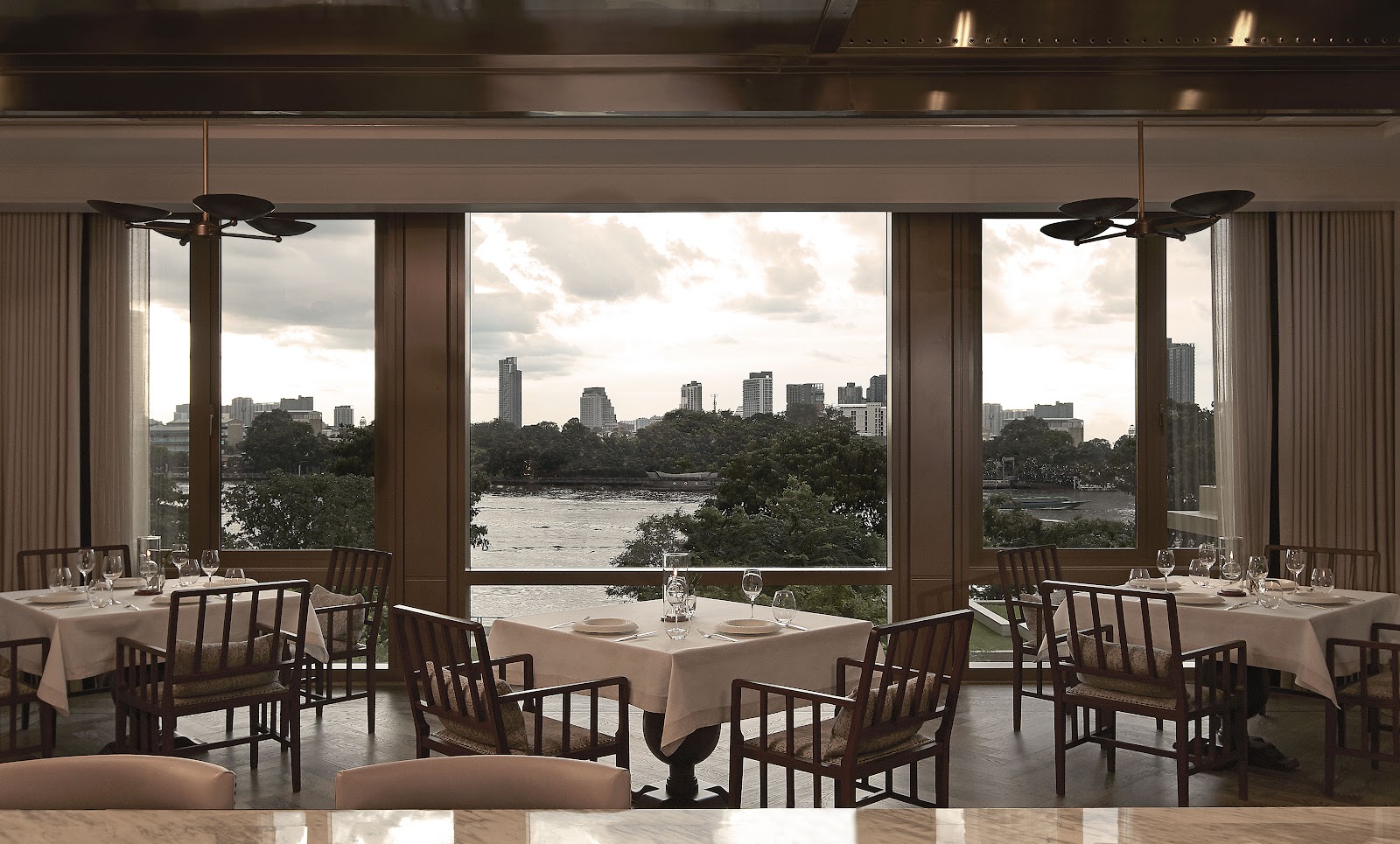 Côte by Mauro Colagreco dining room with tall windows over the river
