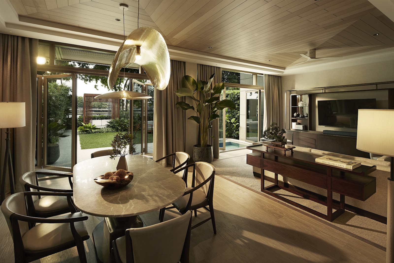 A suite living and dining room with a round table and garden views