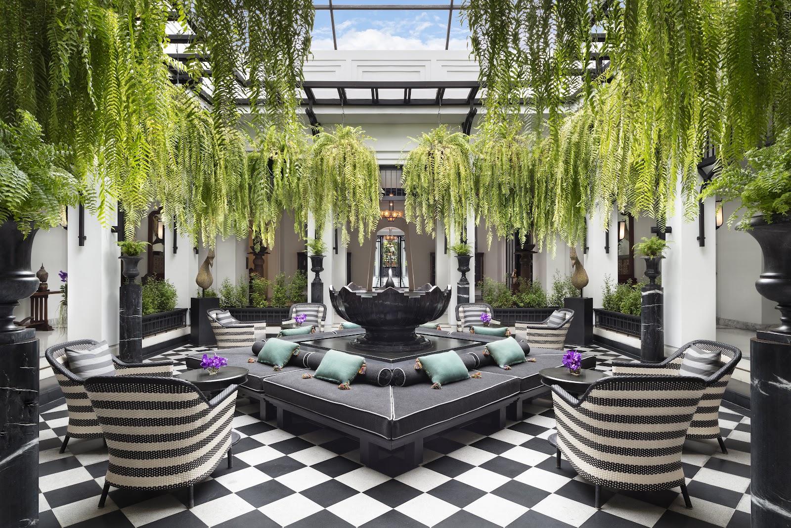 A black-and-white checkered courtyard lounge at The Siam under hanging greenery