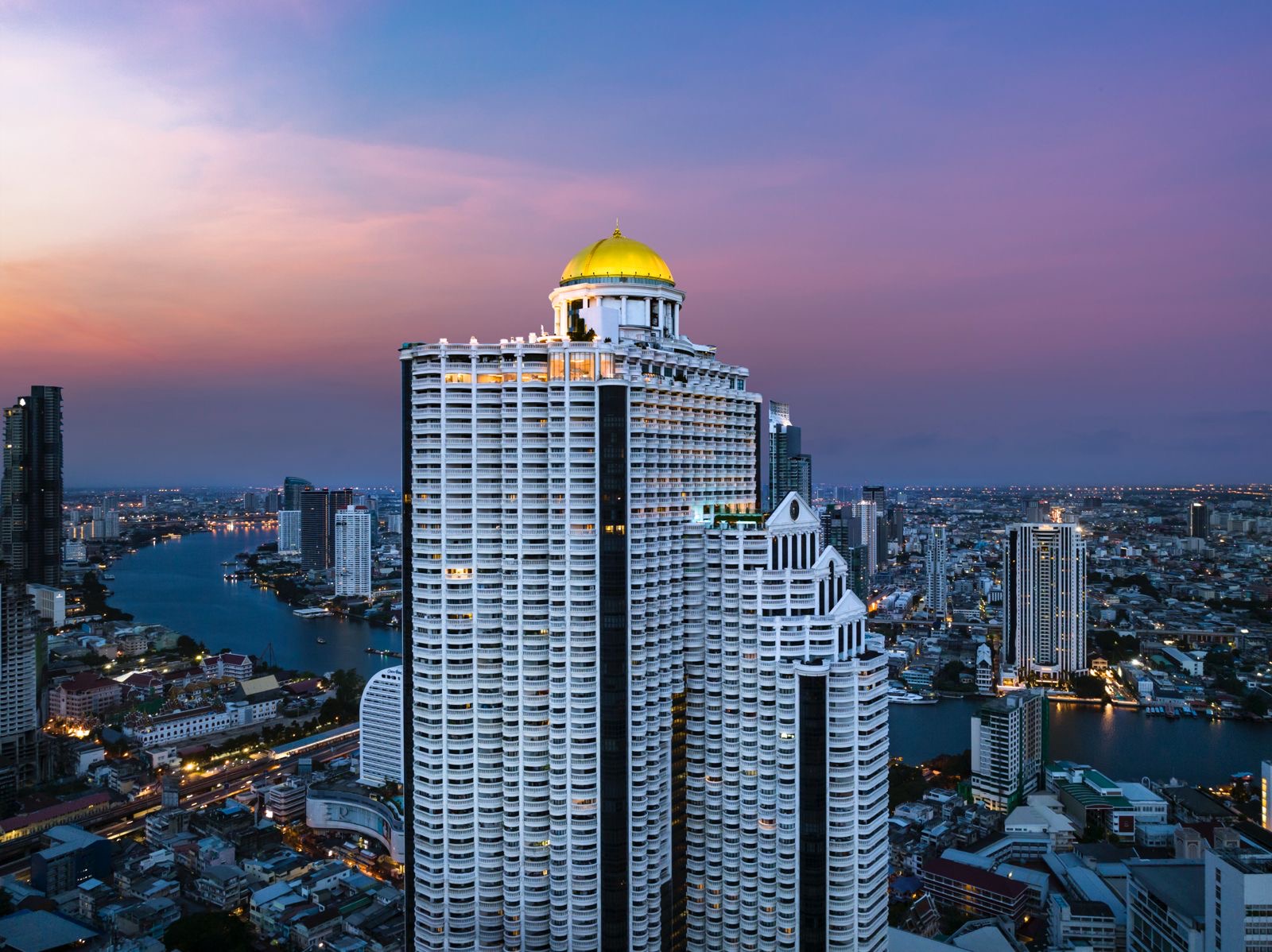 State Tower with its gold dome above Silom Road and the Chao Phraya at dusk