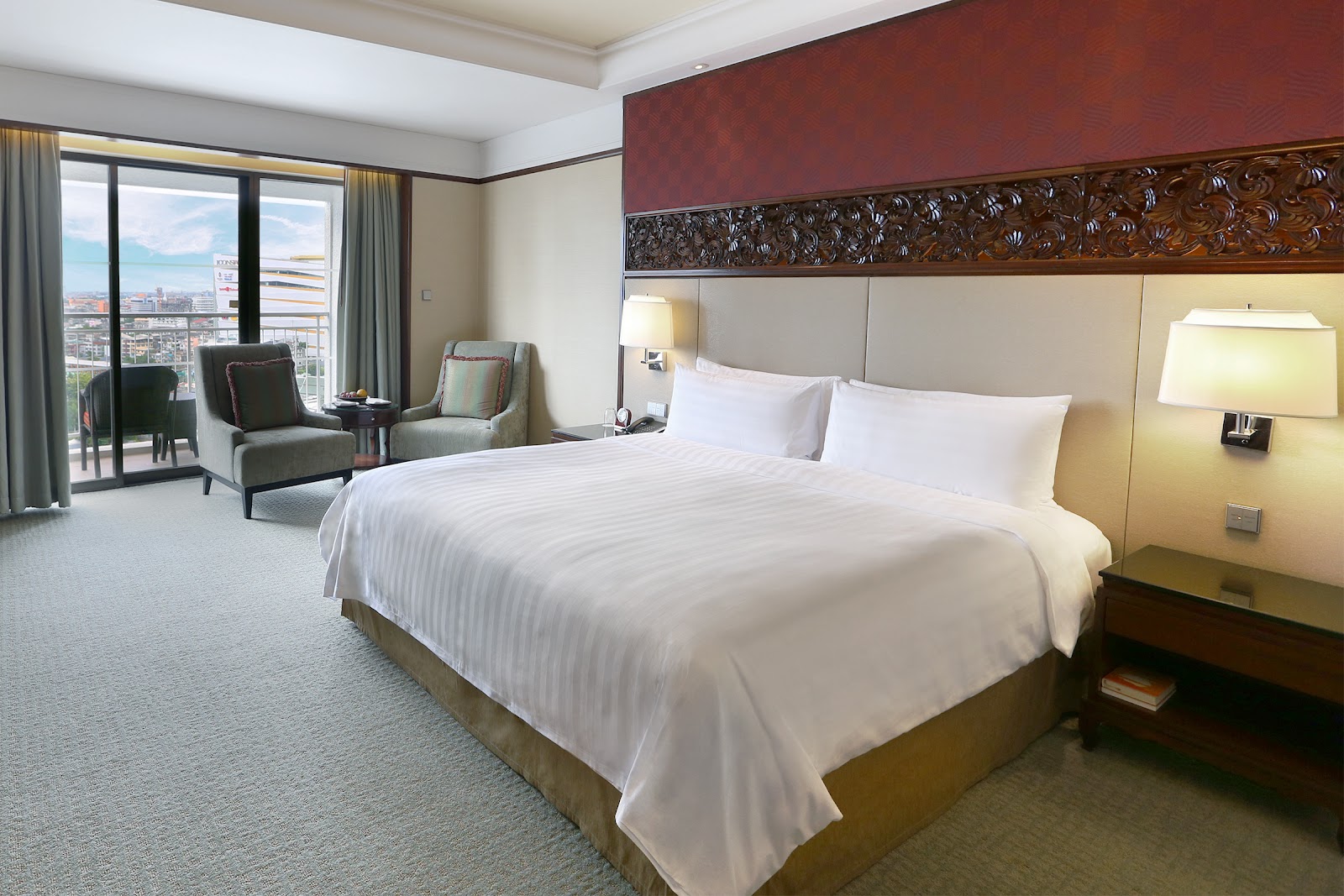 A Shangri-La Bangkok guest room with a king bed and a balcony looking over the river