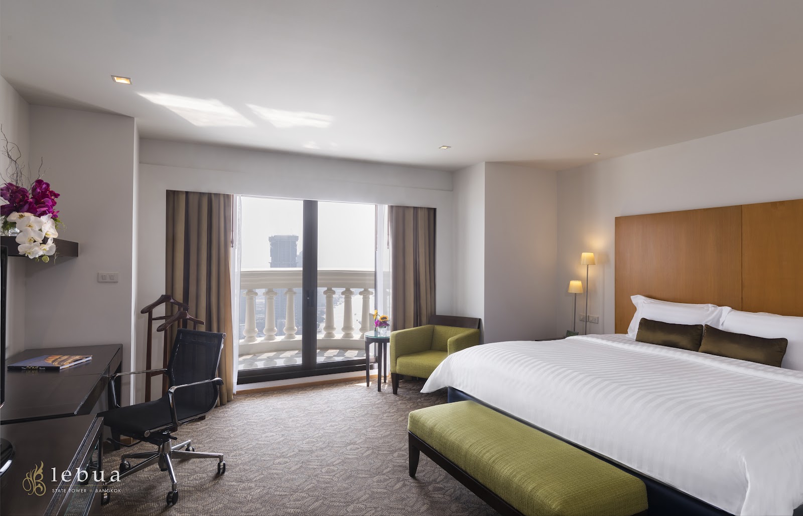 A lebua suite bedroom with a king bed and doors onto a balcony