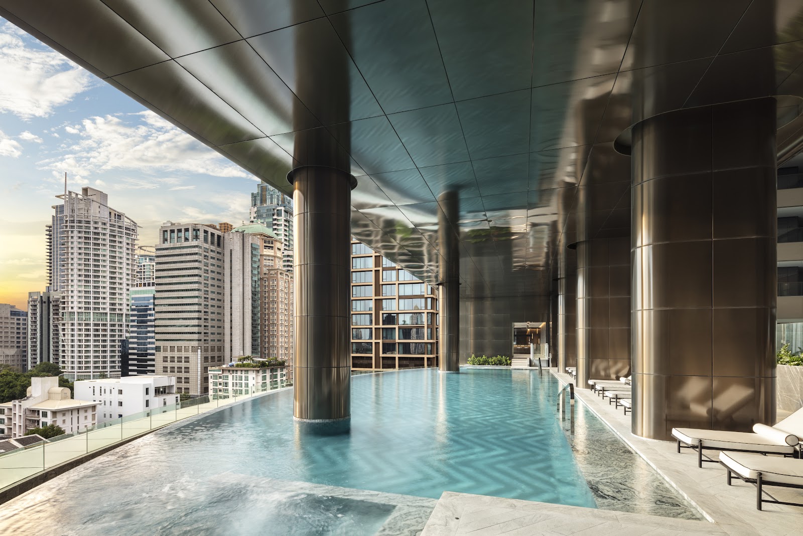 The level-9 outdoor pool running along the building's edge with city towers beyond