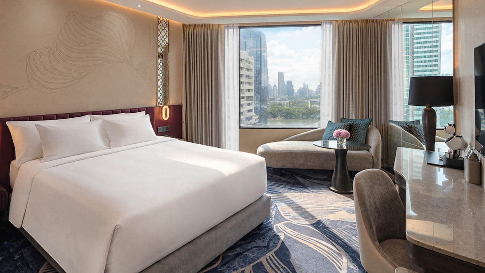 Guest room with a king bed, armchair and window over neighboring towers