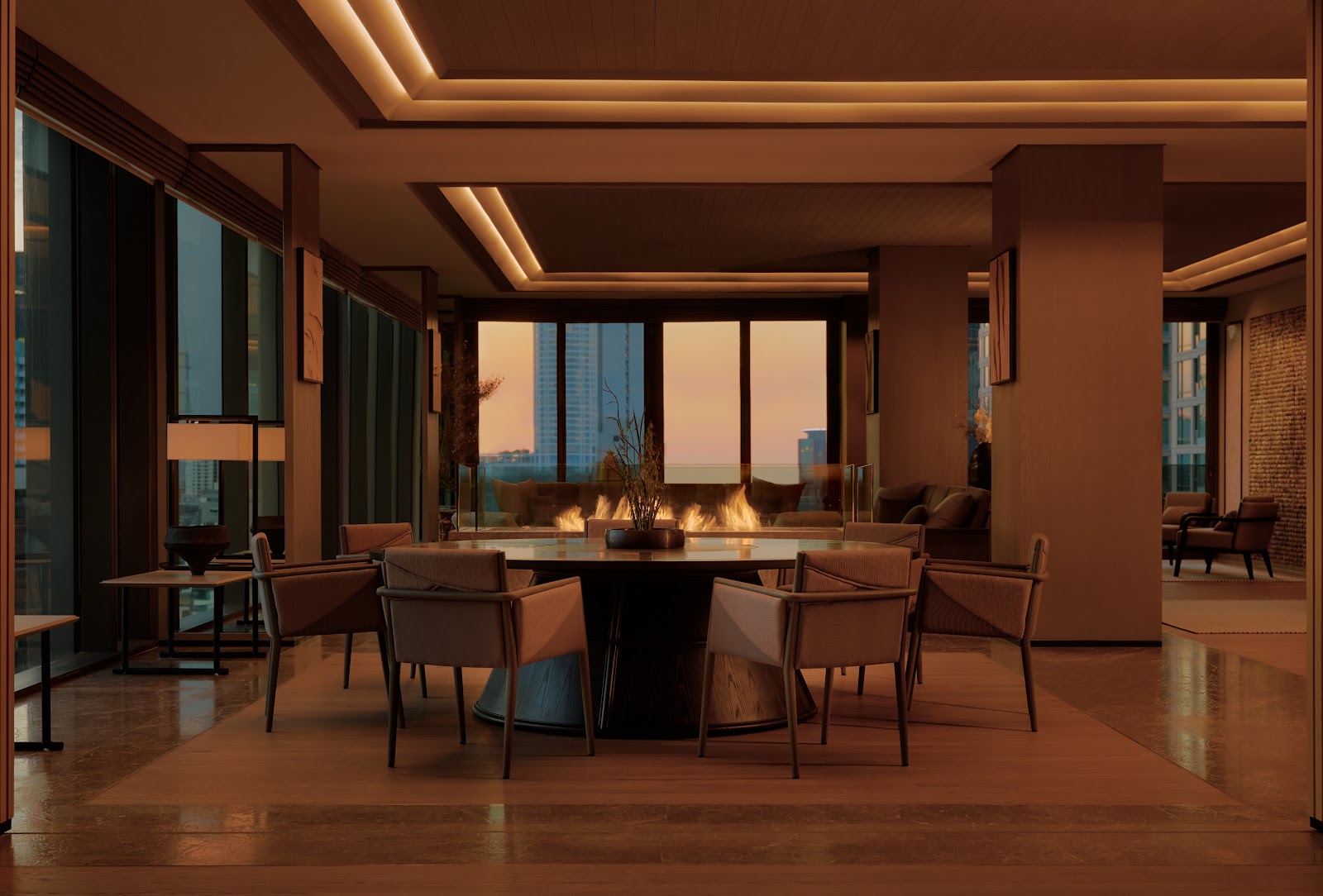Dining room with a round table around a central fire feature and windows at dusk
