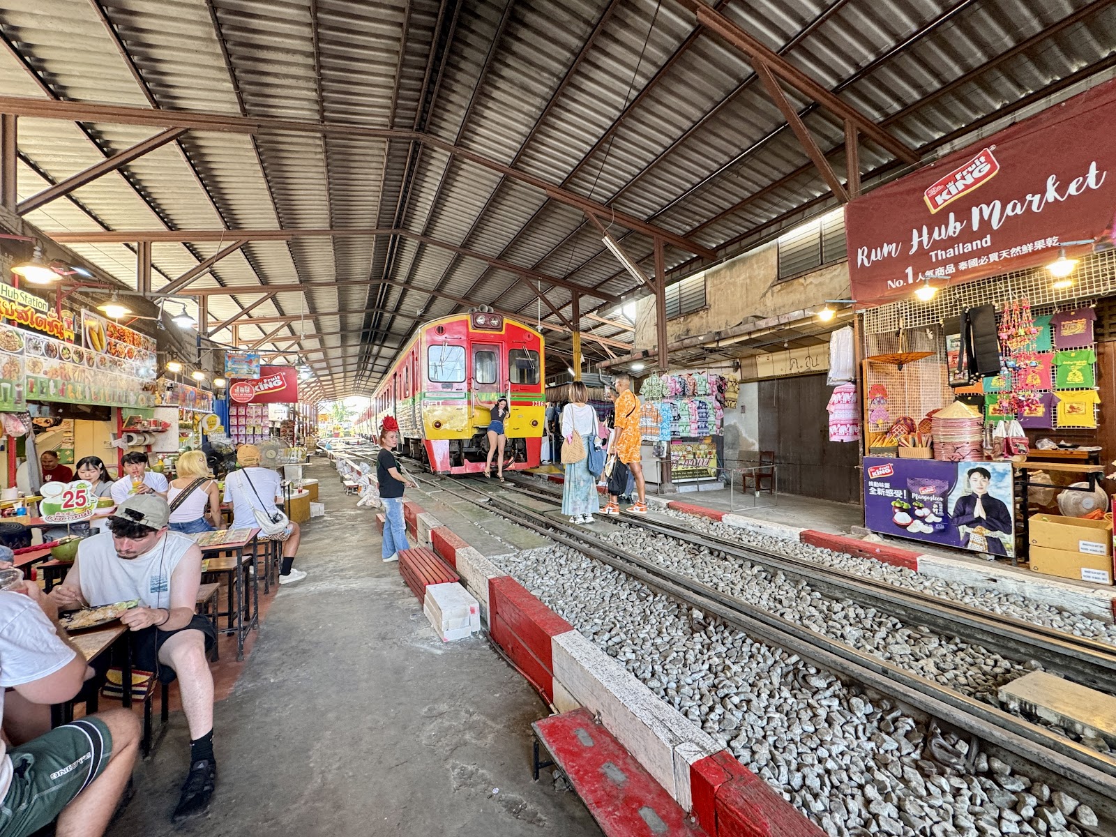 A train standing at the end of the Maeklong Railway Market with stalls along the tracks