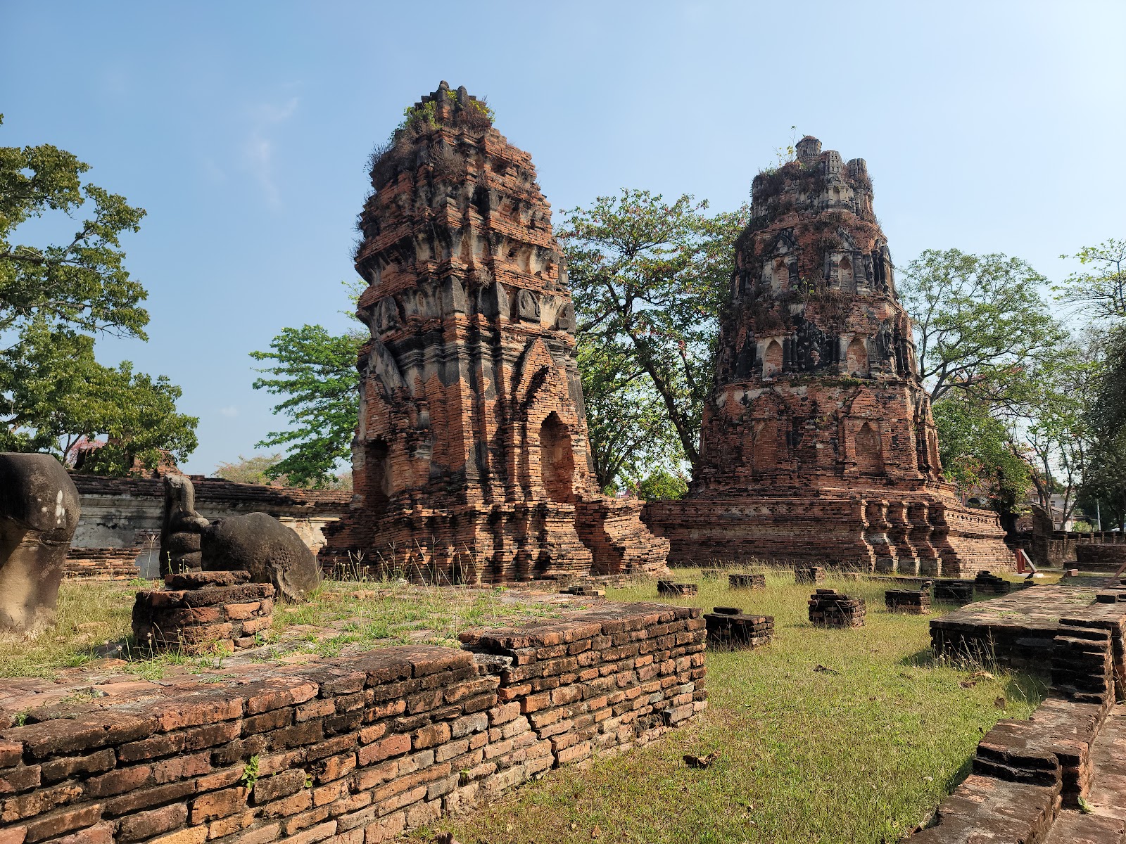 Two weathered brick prangs among the ruins of Wat Mahathat, Ayutthaya