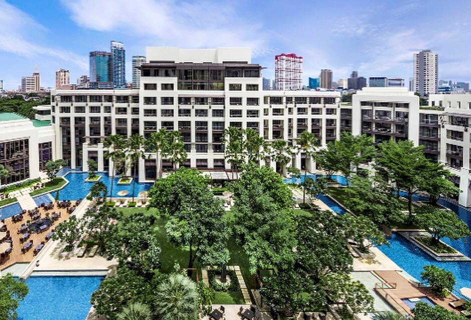 Garden and pools of Siam Kempinski Hotel Bangkok with Siam towers behind