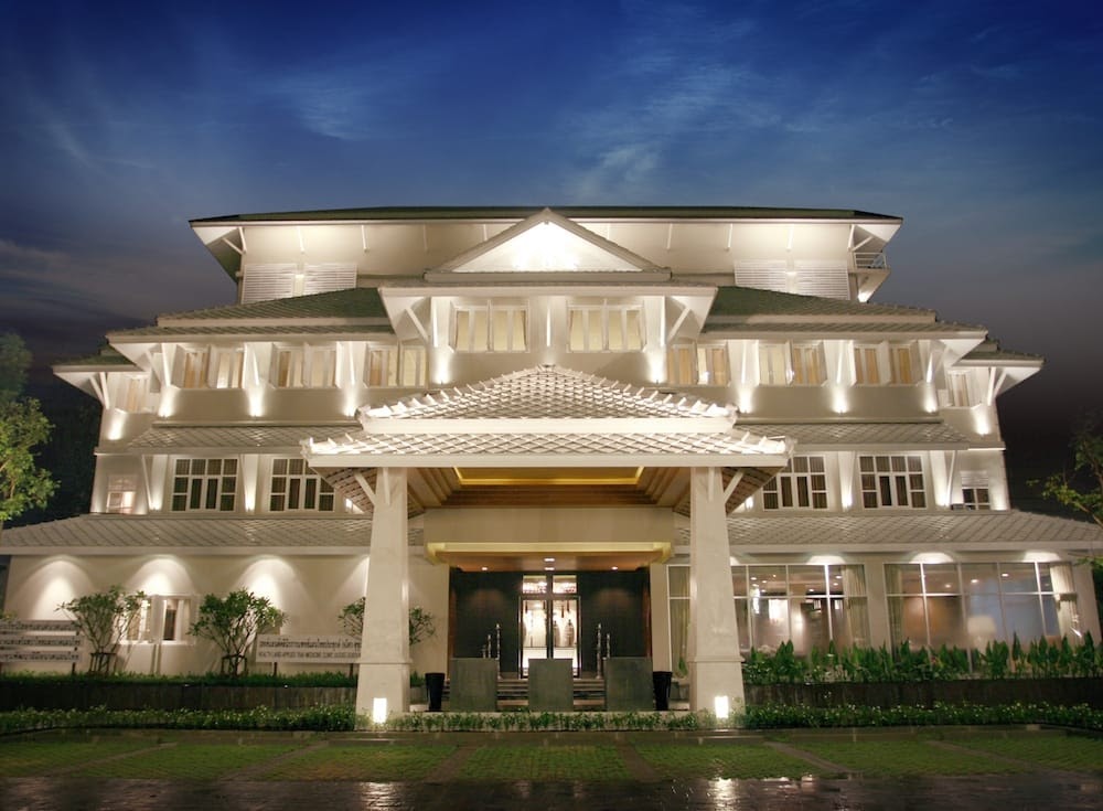 Health Land spa building lit at dusk on Sukhumvit 21, Bangkok